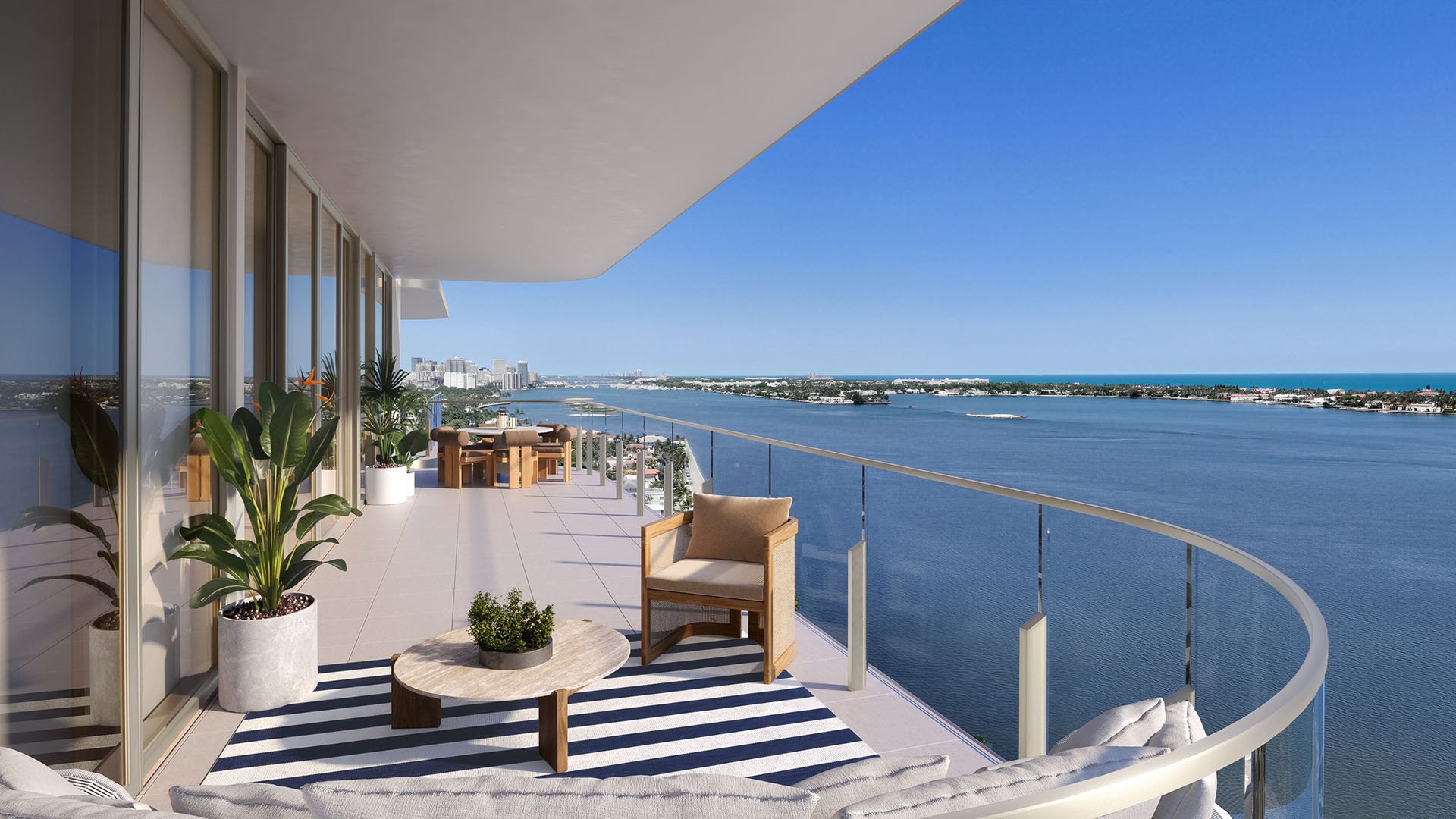 Wraparound waterfront terrace with curved glass railing, lounge seating and open water views at Maison D'Or in West Palm Beach, showcasing luxury and ultra luxury preconstruction condos with expansive balconies.