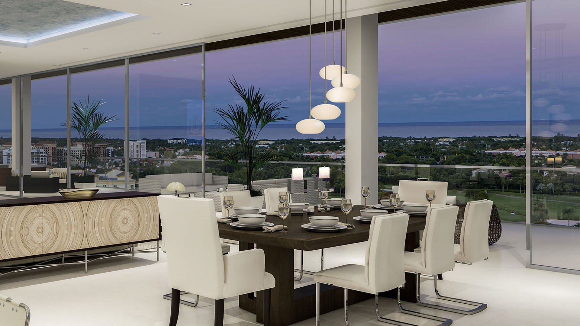 Mandarin Oriental Residences Boca Raton, Florida ocean-view dining room with floor-to-ceiling windows, designer pendant lights and set table at dusk, featuring luxury and ultra luxury preconstruction condos in a resort-style setting.