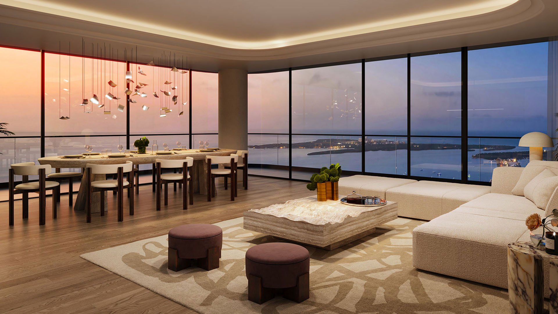 Mercedes-Benz Places Miami in Miami, Florida: luxury and ultra luxury preconstruction condos living and dining room with curved ceiling, sculptural chandelier, designer seating, and expansive floor-to-ceiling windows framing a sunset bay view.