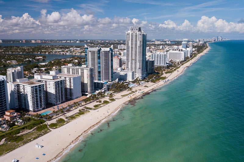 Miami Beach skyline aerial with oceanfront towers and Biscayne Bay, iconic strip for luxury and ultra luxury condos; preconstruction and resale inventory. Featuring view.