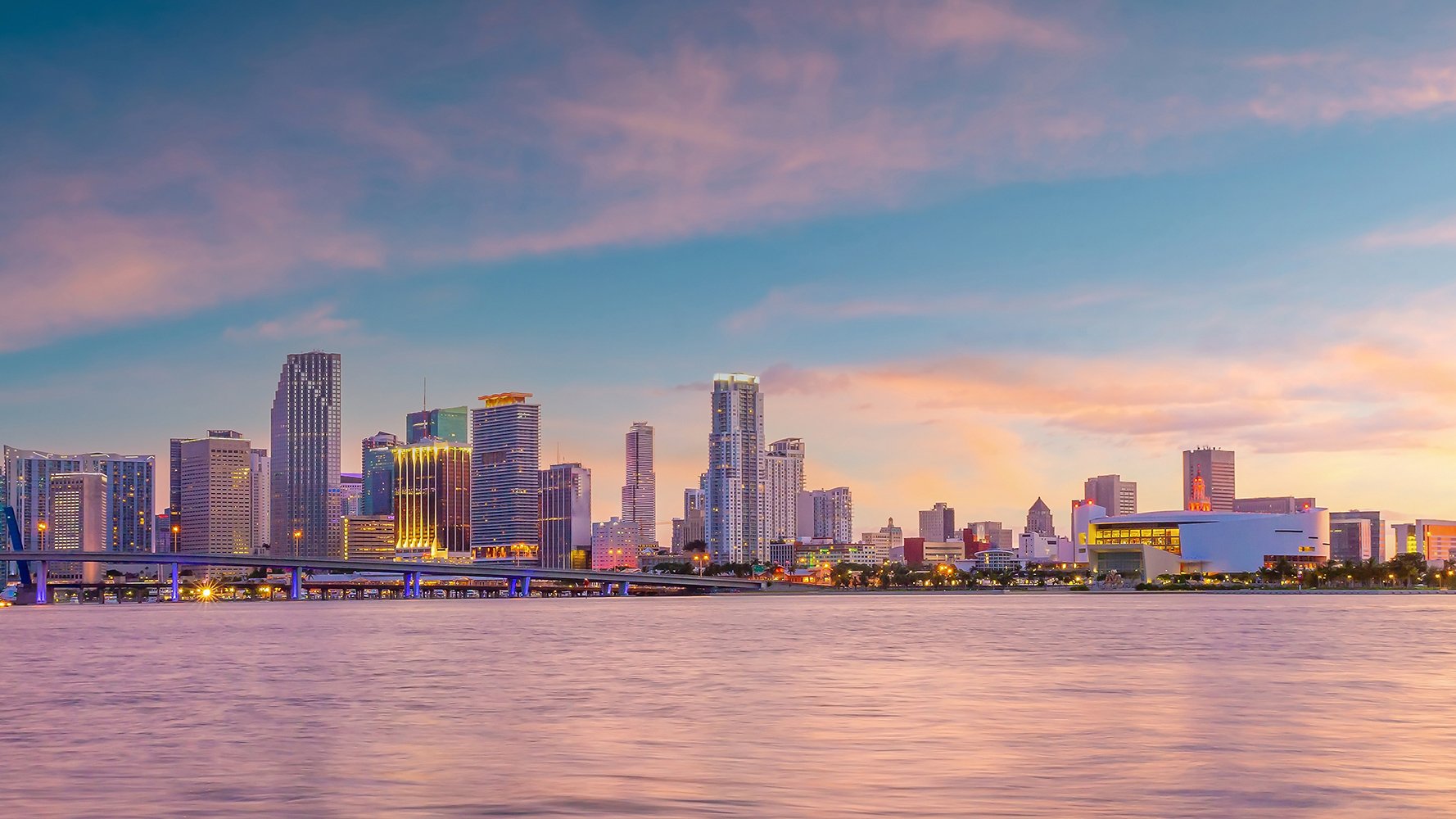 Downtown Miami skyline at sunset with waterfront views; luxury and ultra luxury condos in Downtown Miami, preconstruction lifestyle by the bay.