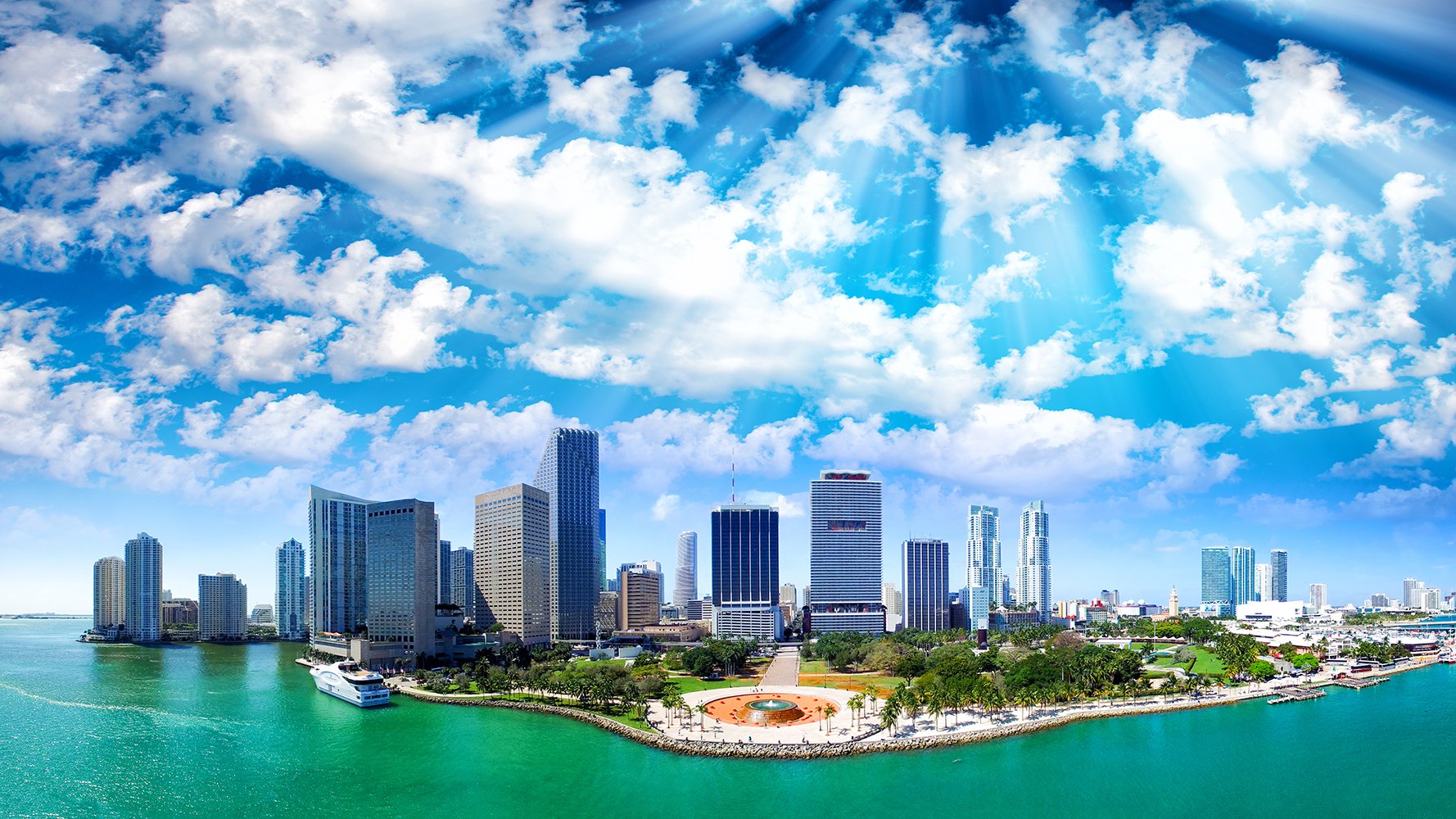 Miami skyline in daylight under blue skies over Biscayne Bay—Downtown Miami, Florida; prime market for luxury and ultra luxury condos with preconstruction and resale opportunities.