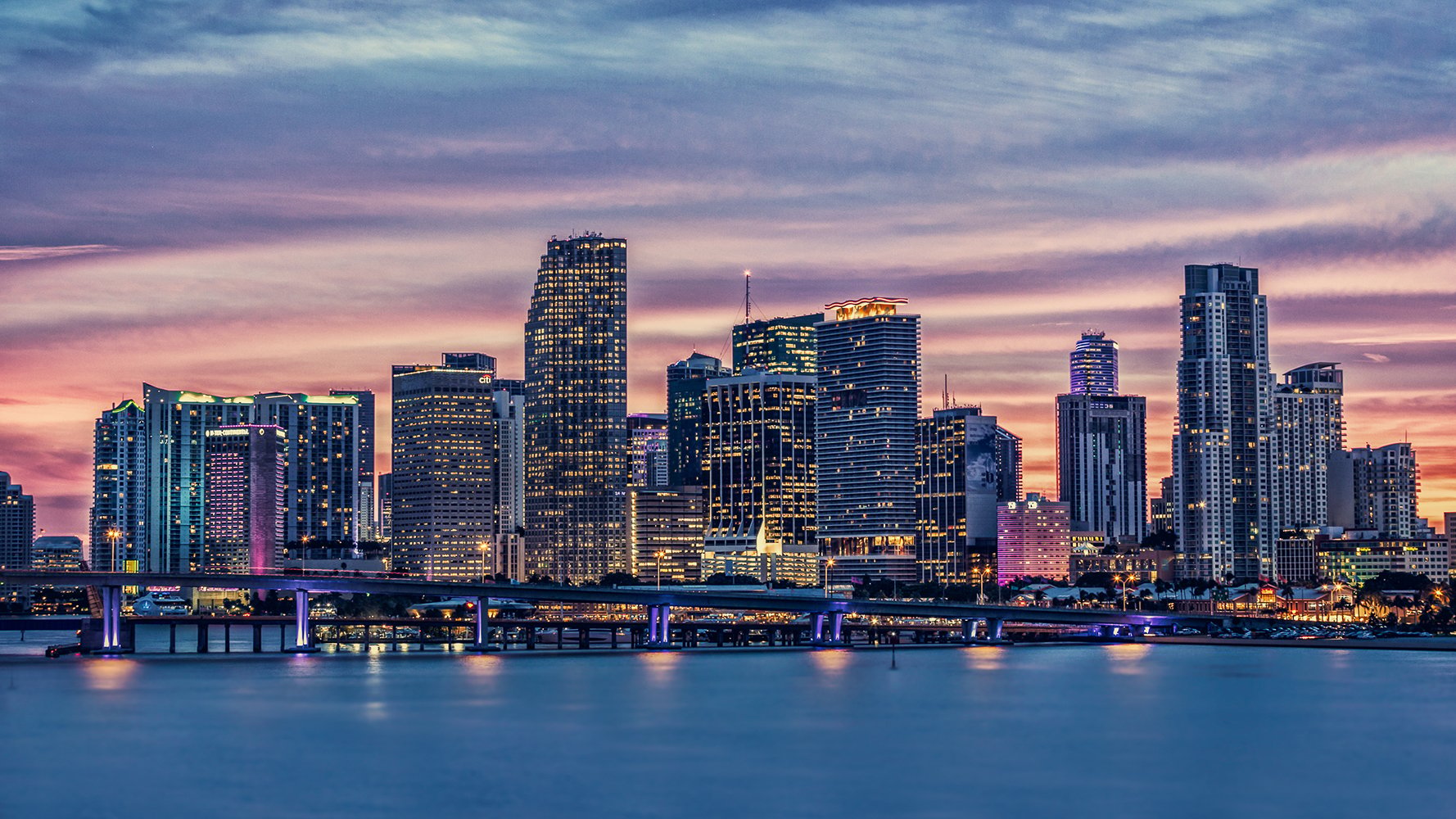 Miami sunset skyline over marinas and Biscayne Bay—Downtown Miami; vibrant zone for luxury and ultra luxury condos; preconstruction and resale inventory.