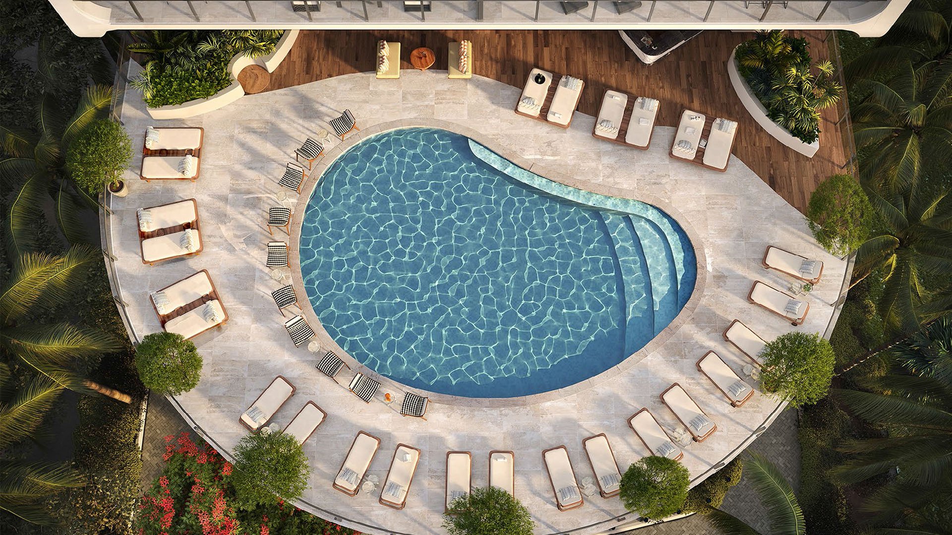 Aerial view of the pool terrace with loungers surrounding the water at Mr C Residences Bayshore Tower in Coconut Grove, showcasing luxury, ultra luxury condos with a resort style outdoor amenity terrace.