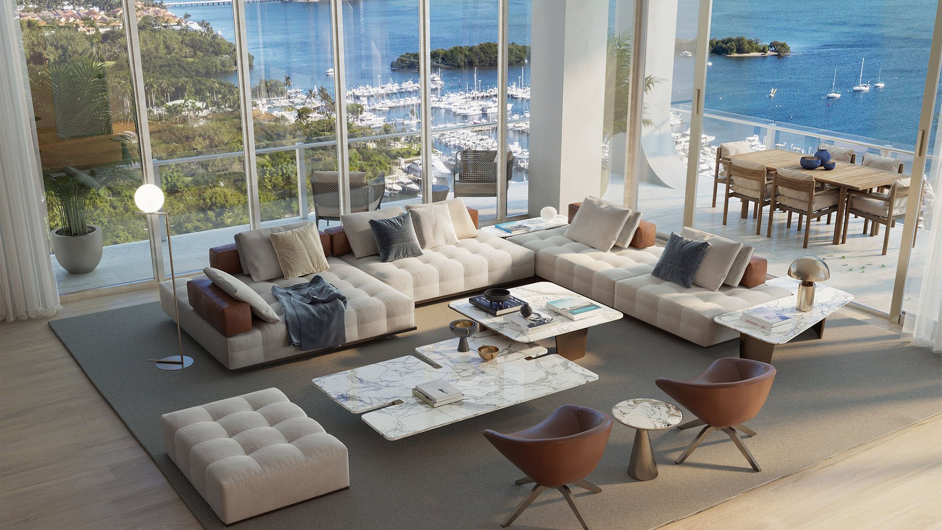 Bayfront great room with a wraparound sofa, marble tables, and terrace dining beyond the glass at Mr C Residences Bayshore Tower in Coconut Grove, presenting luxury, ultra luxury condos with expansive waterfront living.