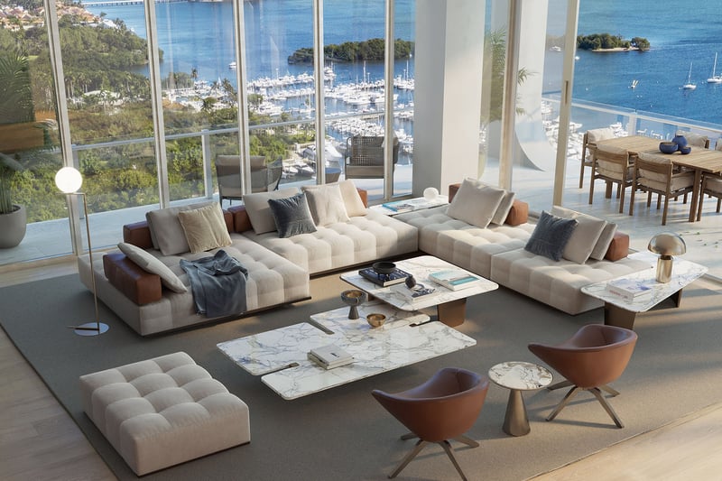 Bayfront great room with a wraparound sofa, marble tables, and terrace dining beyond the glass at Mr C Residences Bayshore Tower in Coconut Grove, presenting luxury, ultra luxury condos with expansive waterfront living.