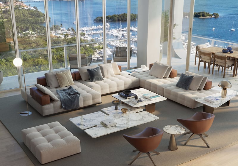 Bayfront great room with a wraparound sofa, marble tables, and terrace dining beyond the glass at Mr C Residences Bayshore Tower in Coconut Grove, presenting luxury, ultra luxury condos with expansive waterfront living.