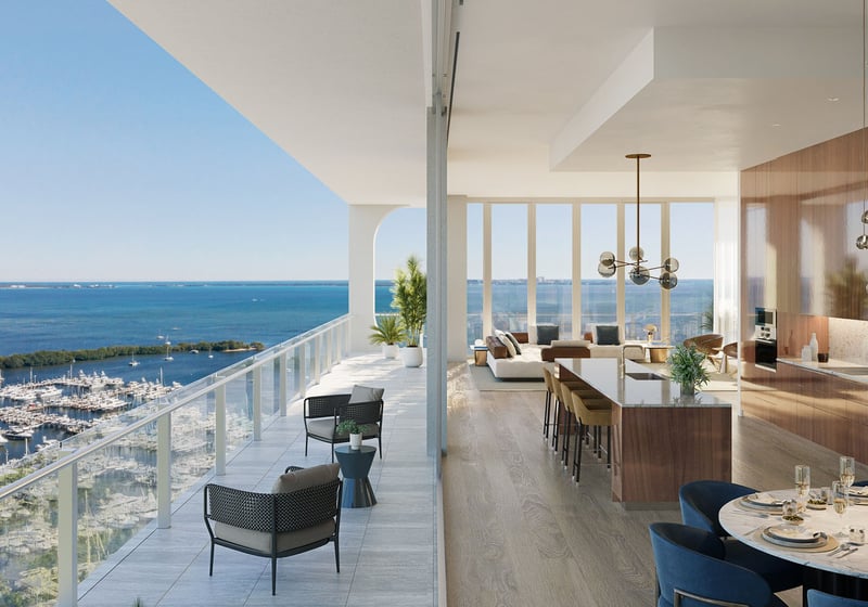 Chef kitchen with island seating, a round dining table, and sweeping marina views at Mr C Residences Bayshore Tower in Coconut Grove, showcasing luxury, ultra luxury condos with wraparound waterfront exposure.