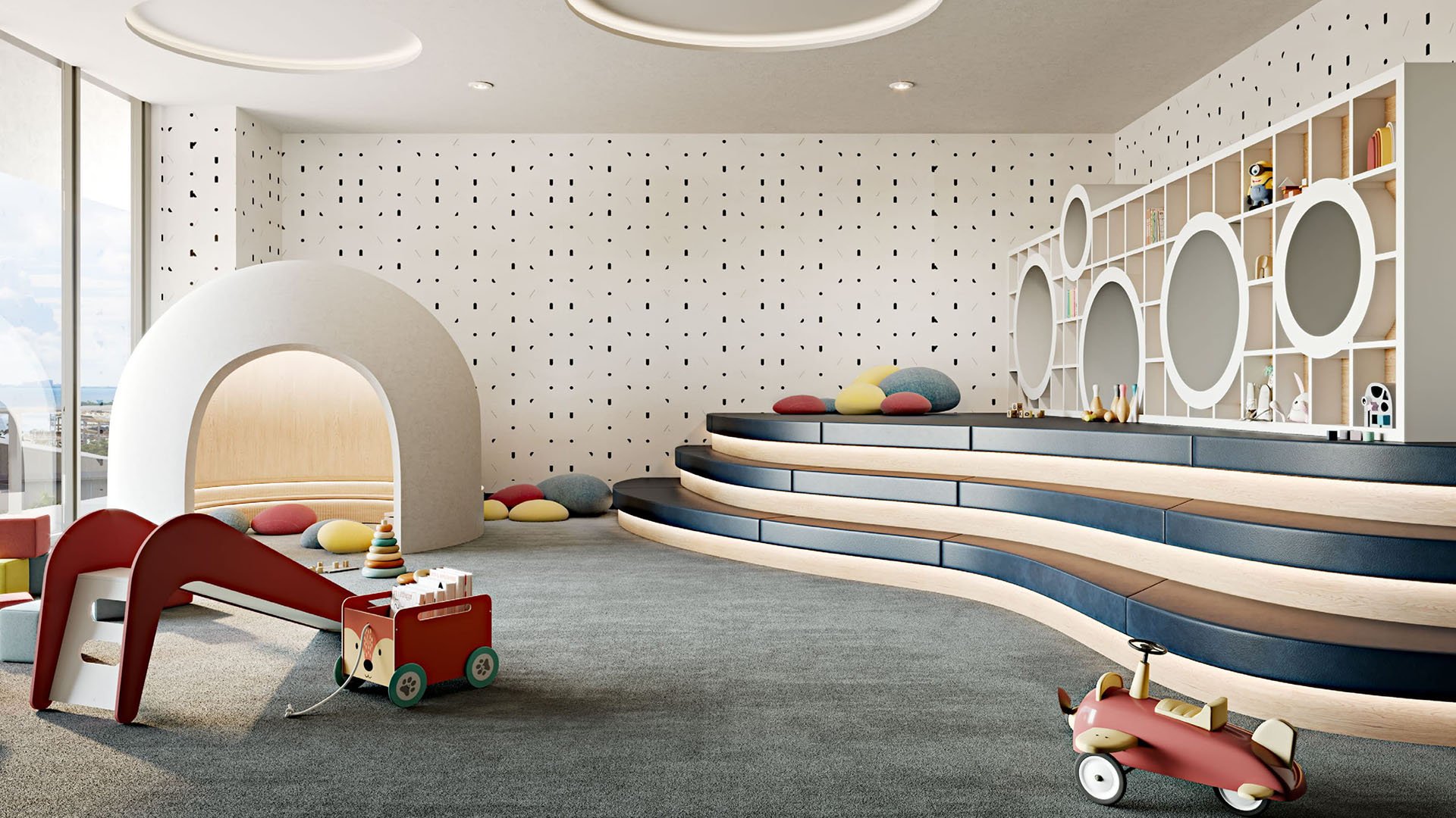 Children playroom with circular shelving, tiered seating, a slide, and soft toys at Mr C Residences Bayshore Tower in Coconut Grove, showcasing luxury, ultra luxury condos with family friendly amenity space.