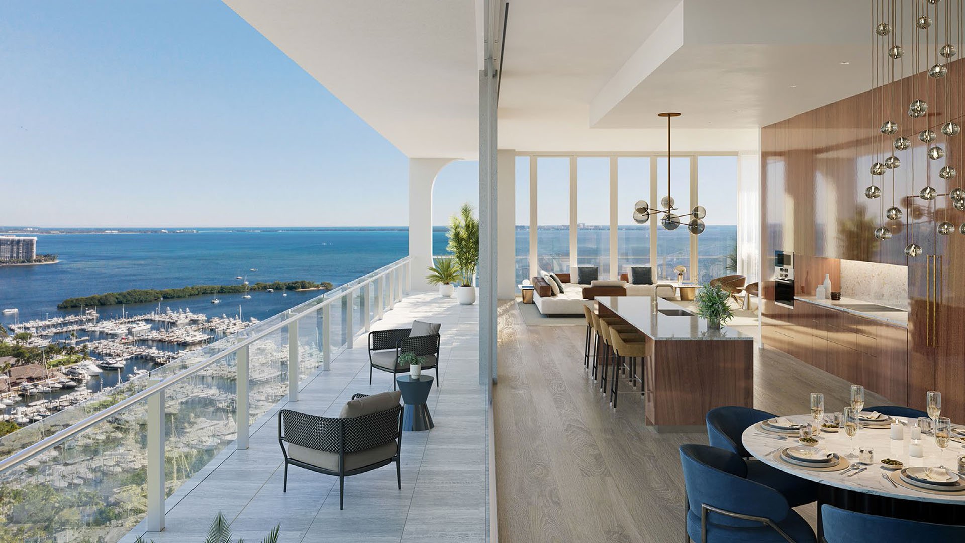 Corner chef kitchen and dining area beside a wraparound balcony and marina views at Mr C Residences Bayshore Tower in Coconut Grove, highlighting luxury, ultra luxury condos with dramatic indoor outdoor entertaining.