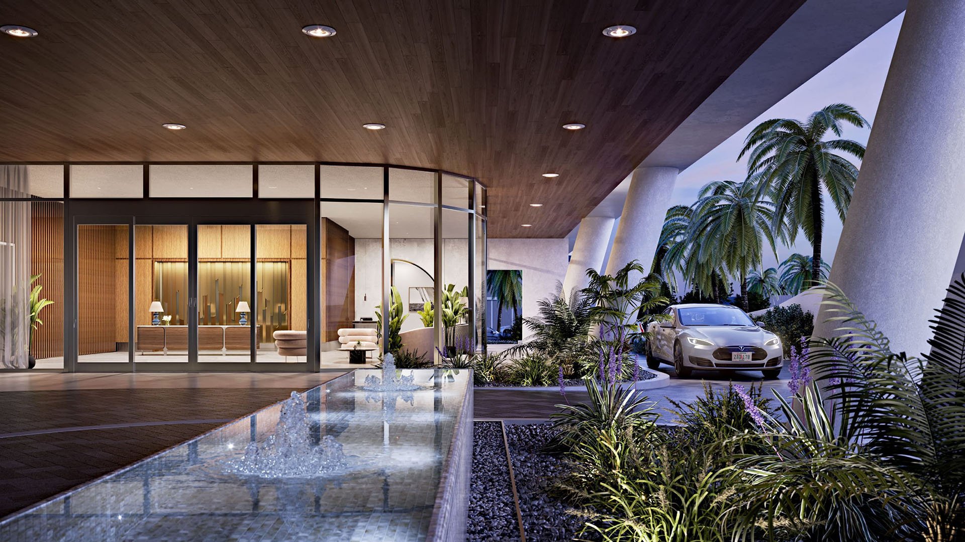 Covered arrival court with a water feature, valet drive, and lush planting at Mr C Residences Bayshore Tower in Coconut Grove, featuring luxury, ultra luxury condos with a dramatic hospitality inspired entrance.