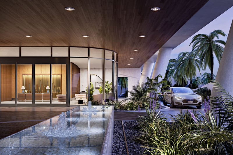 Covered arrival court with a water feature, valet drive, and lush planting at Mr C Residences Bayshore Tower in Coconut Grove, featuring luxury, ultra luxury condos with a dramatic hospitality inspired entrance.
