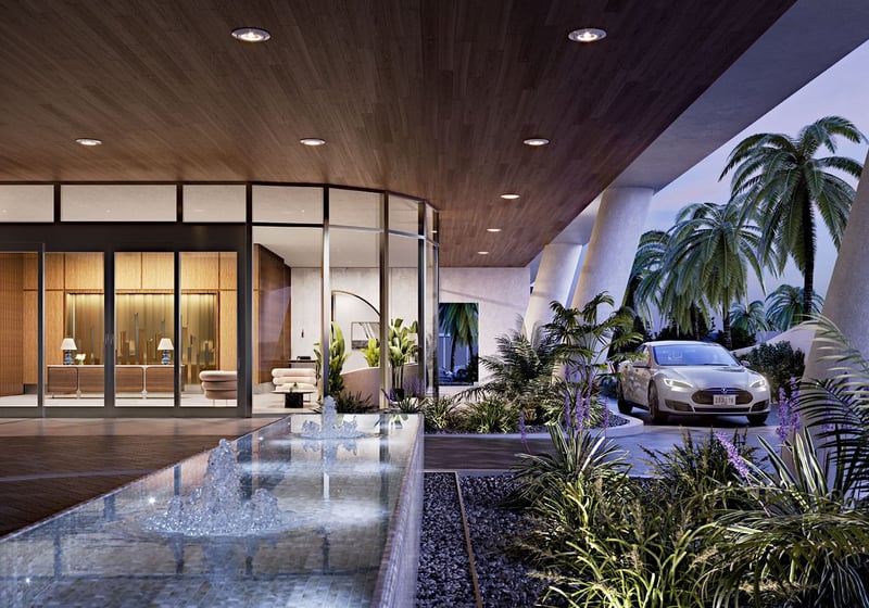 Covered arrival court with a water feature, valet drive, and lush planting at Mr C Residences Bayshore Tower in Coconut Grove, featuring luxury, ultra luxury condos with a dramatic hospitality inspired entrance.