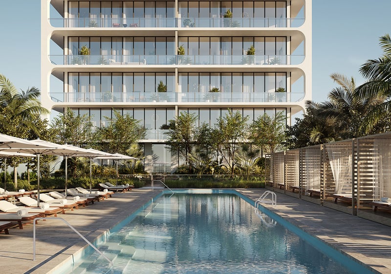 Lap pool with loungers, cabanas, and palm framed courtyards at Mr C Residences Bayshore Tower in Coconut Grove, presenting luxury, ultra luxury condos with resort style outdoor amenities.