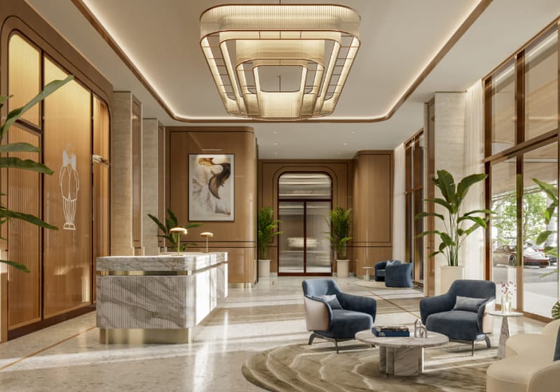 Grand lobby at Mr. C Residences in Boca Raton with a marble reception desk, lounge seating, tall windows, and warm finishes, presenting preconstruction luxury and ultra luxury condos.