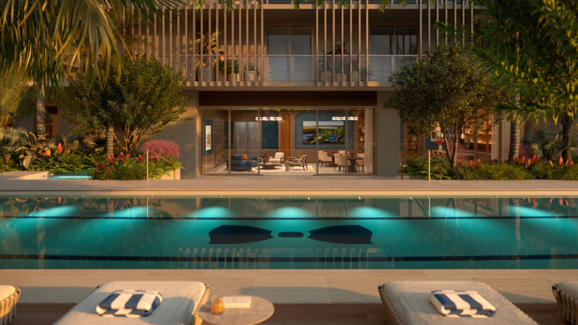 Resort pool deck at Mr. C Residences in Boca Raton with an open-air club lounge, underwater lighting, and chaise seating, highlighting preconstruction luxury and ultra luxury condos.