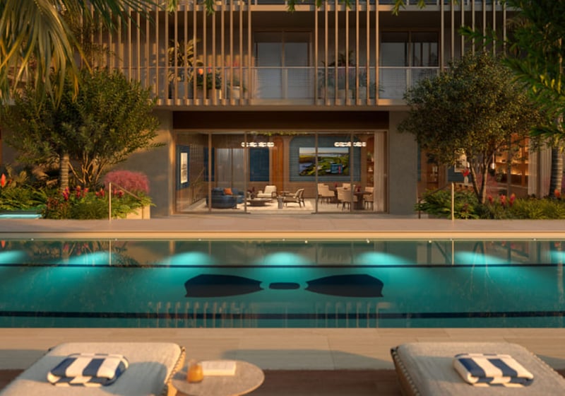 Resort pool deck at Mr. C Residences in Boca Raton with an open-air club lounge, underwater lighting, and chaise seating, highlighting preconstruction luxury and ultra luxury condos.