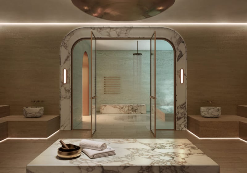 Spa steam room at Mr. C Residences in Boca Raton with marble benches, glass doors, and warm ambient lighting, reflecting amenities for preconstruction luxury and ultra luxury condos.