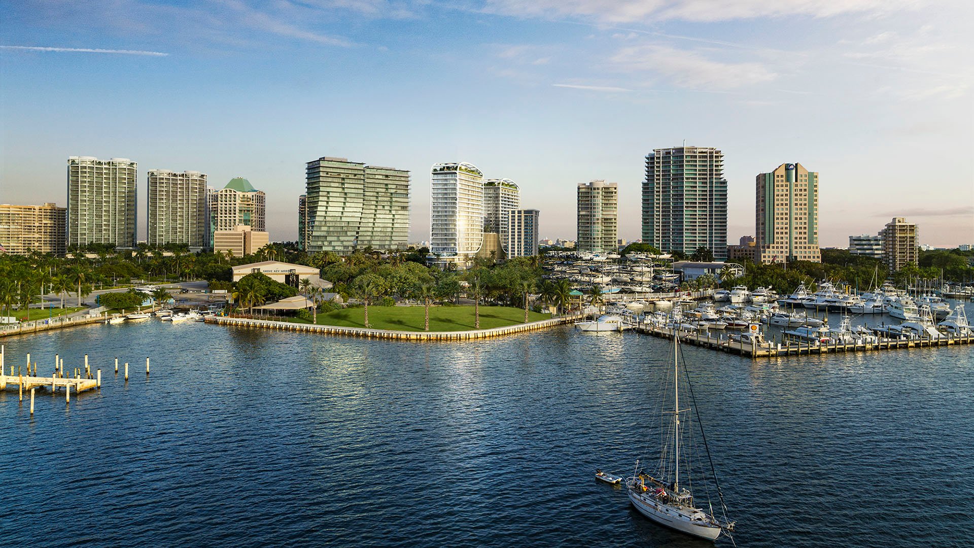 Aerial waterfront view of Mr. C Residences Tigertail Tower, Coconut Grove, with a marina, shoreline green space and nearby towers, highlighting luxury and ultra luxury condos by the bay.