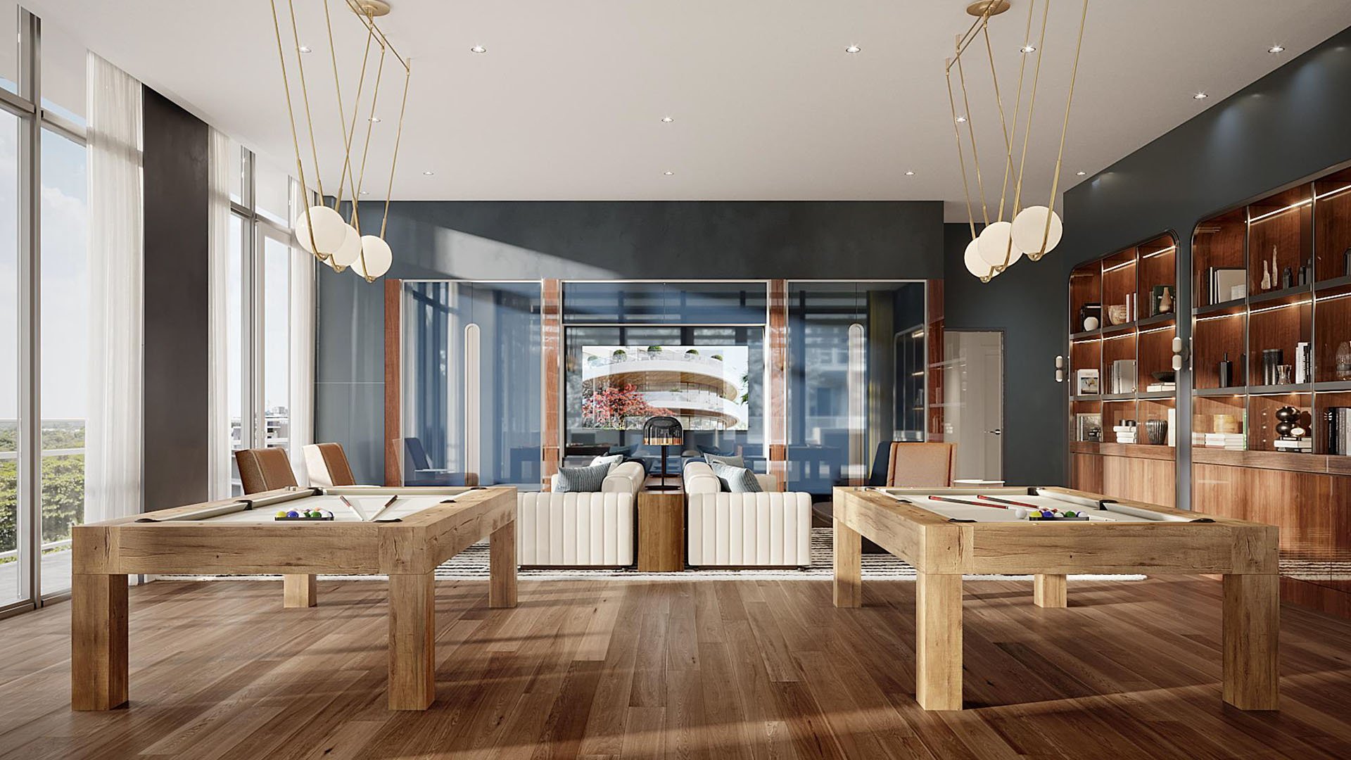 Billiards room with dual pool tables, wood floors and built-in shelving at Mr. C Residences Tigertail Tower, Coconut Grove, an amenity for luxury and ultra luxury condos.