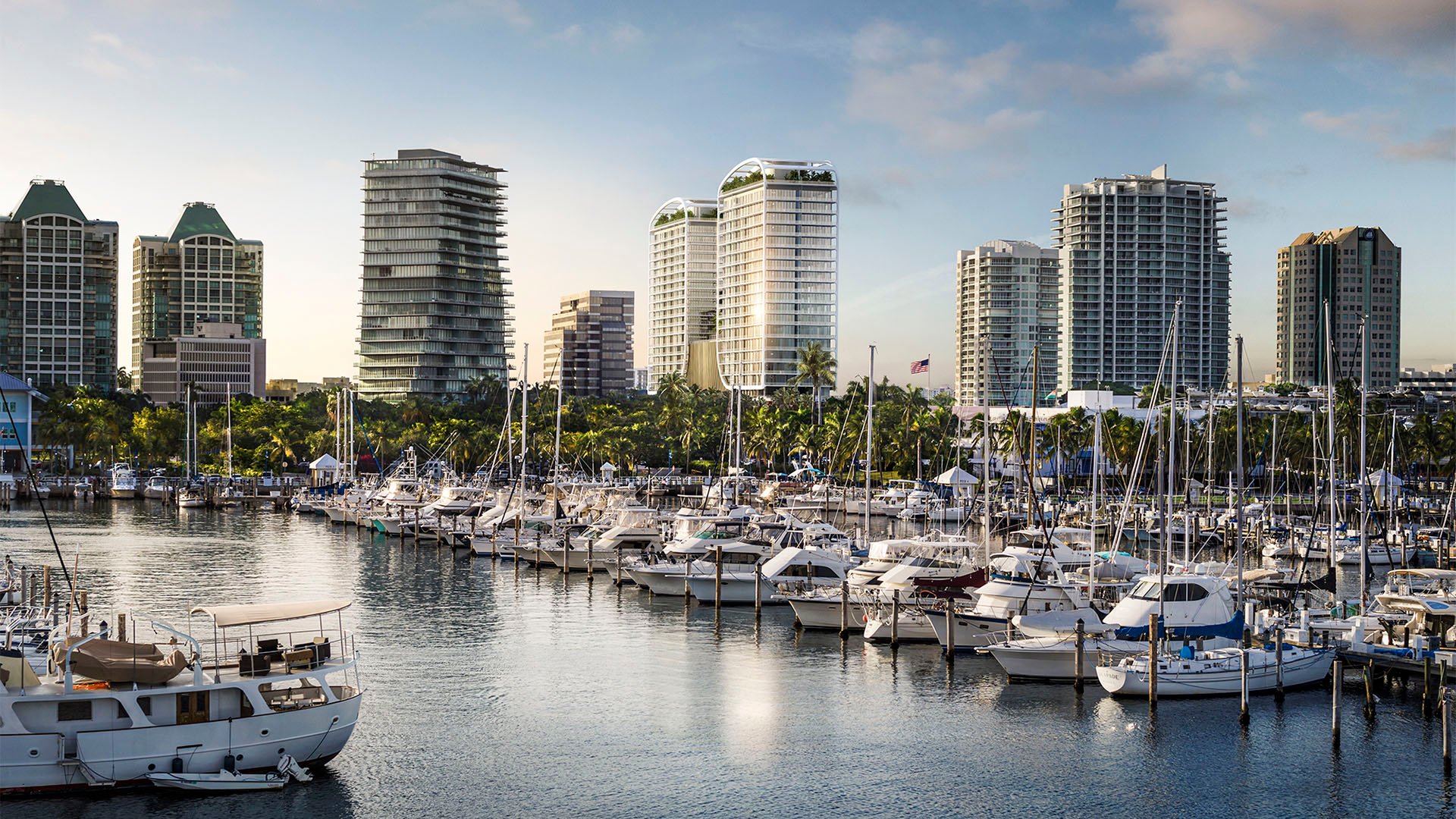 Marina waterfront view toward Mr. C Residences Tigertail Tower, Coconut Grove, with yachts and neighboring skyline, spotlighting luxury and ultra luxury condos.