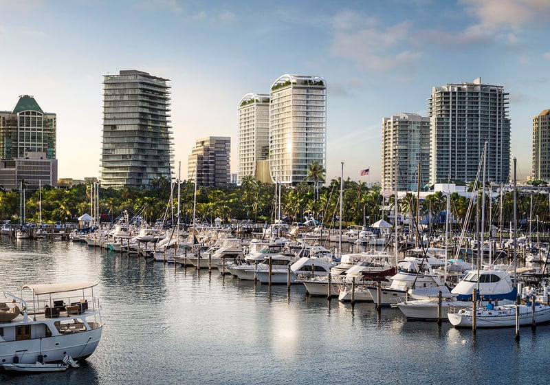 Marina waterfront view toward Mr. C Residences Tigertail Tower, Coconut Grove, with yachts and neighboring skyline, spotlighting luxury and ultra luxury condos.