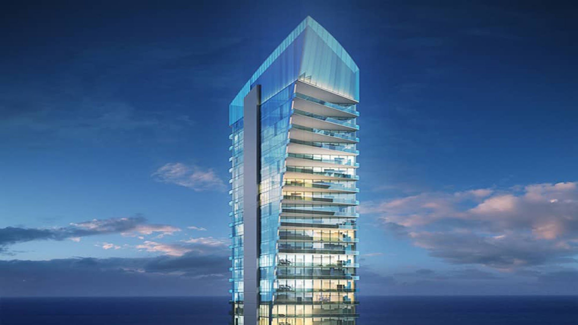 Illuminated glass tower at blue hour at Muse Residences in Sunny Isles Beach, showcasing the striking architecture of luxury and ultra luxury oceanfront condos.