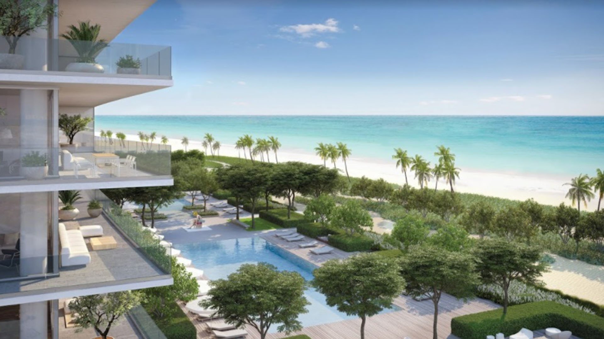 Beachfront pool courtyard framed by condo balconies, lush landscaping and a turquoise ocean backdrop at Oceana Bal Harbour in Bal Harbour, Florida, showcasing the luxury setting of these ultra luxury condos.