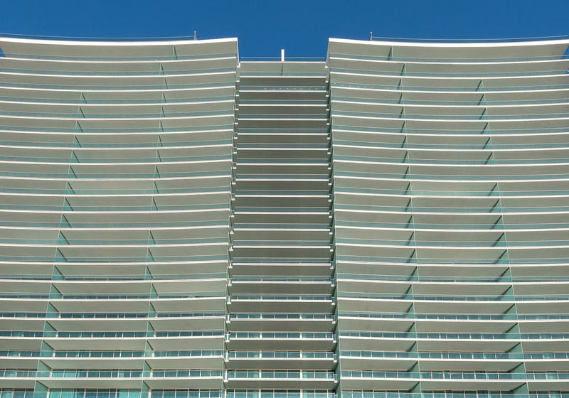 Curved condo exterior with sweeping glass balconies rising against a clear blue sky at Oceana Bal Harbour in Bal Harbour, Florida, emphasizing the luxury architecture of these ultra luxury condos.