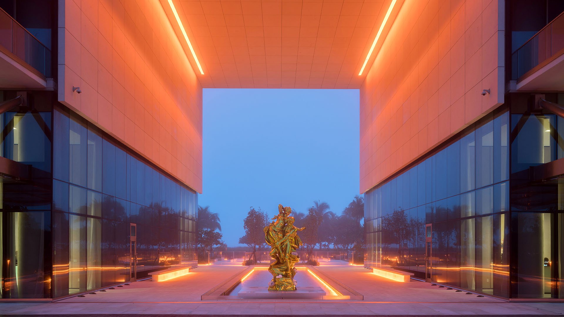 Dusk courtyard view with a lit sculpture between glass towers at Oceana Bal Harbour in Bal Harbour, Florida, conveying the dramatic luxury ambiance that defines these ultra luxury condos.