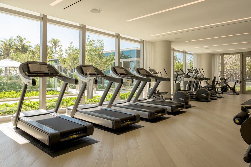 Fitness center with treadmills, cardio equipment and garden facing windows at Oceana Bal Harbour in Bal Harbour, Florida, extending the luxury wellness amenities of these ultra luxury condos.