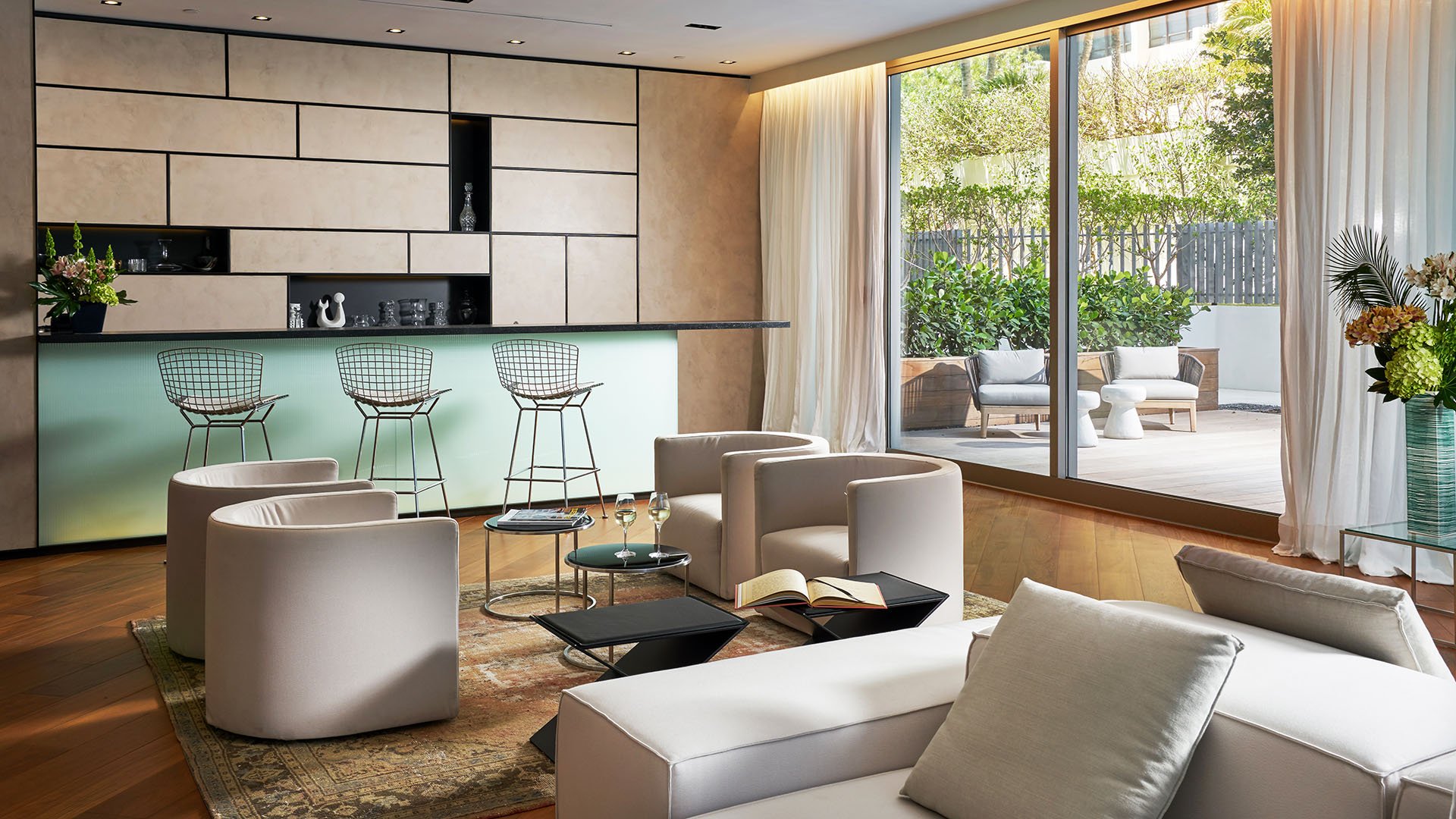 Party room with a bar lounge, soft seating and patio access at Oceana Bal Harbour in Bal Harbour, Florida, demonstrating the entertaining luxury amenities available in these ultra luxury condos.