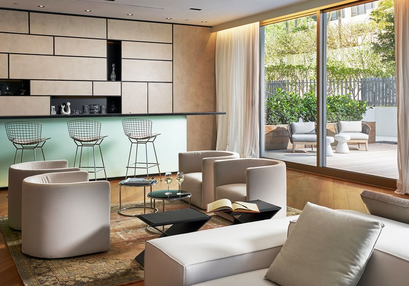 Party room with a bar lounge, soft seating and patio access at Oceana Bal Harbour in Bal Harbour, Florida, demonstrating the entertaining luxury amenities available in these ultra luxury condos.