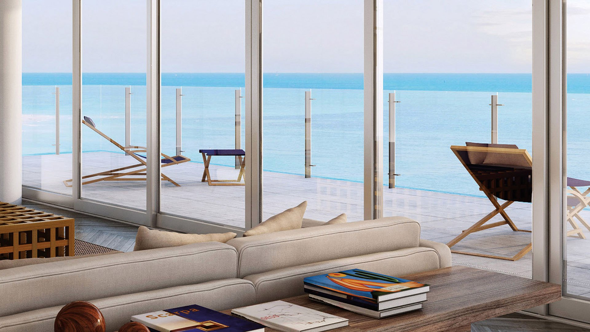 Ocean-view sitting room at Oceana Key Biscayne in Key Biscayne, showing luxury and ultra luxury condos opening to a glass-railed terrace with lounge chairs and uninterrupted water views.