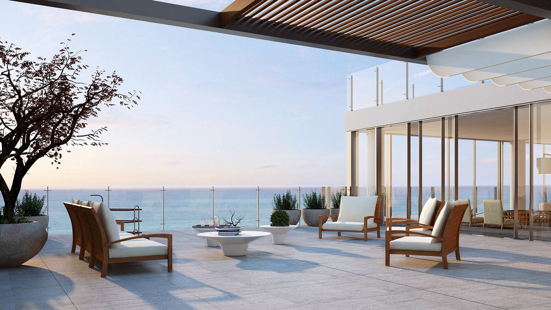 Ocean-view terrace lounge at Oceana Key Biscayne in Key Biscayne, where luxury and ultra luxury condos offer open-air seating, a slatted overhead canopy, glass railings, and expansive water views.