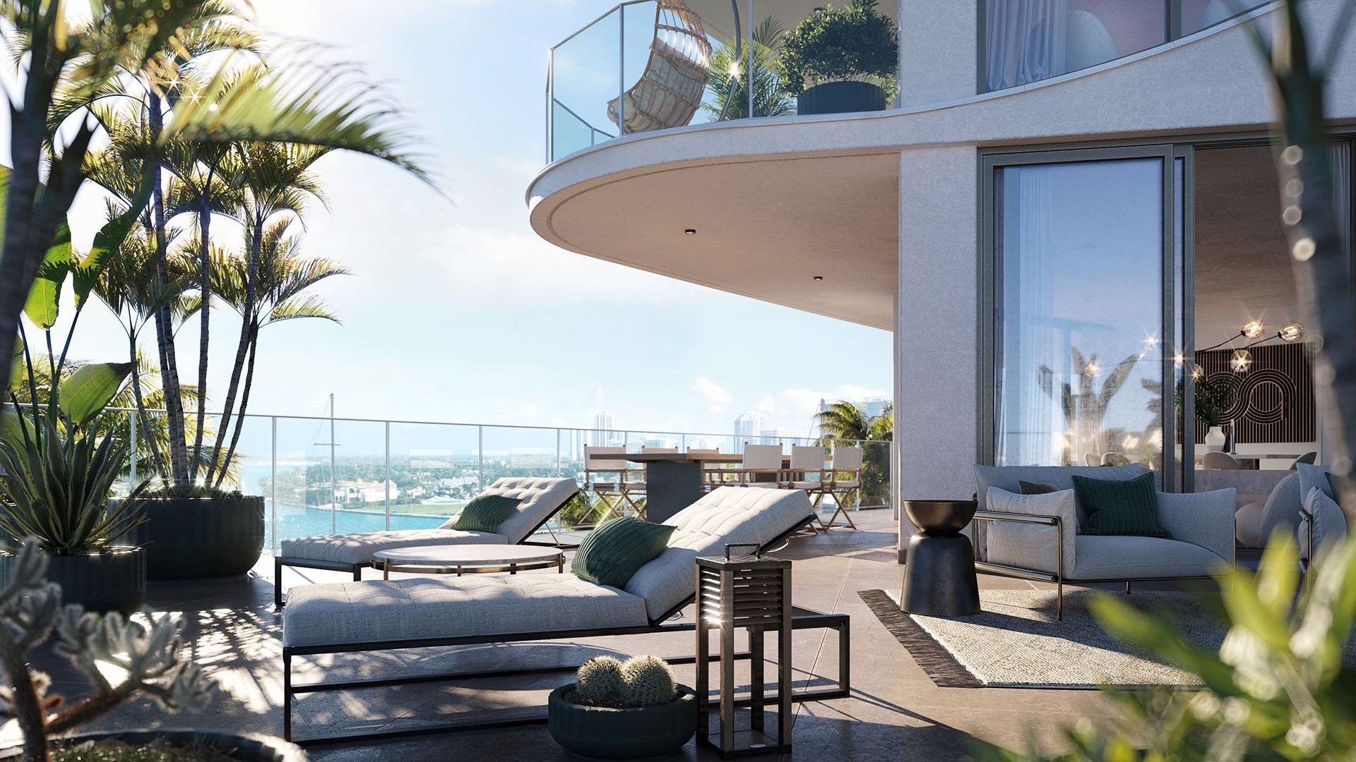Private waterfront terrace at Onda, Bay Harbor Islands, Miami, Florida, with lounge chairs, outdoor seating and glass railings overlooking the bay, showcasing luxury and ultra luxury preconstruction condos lifestyle.
