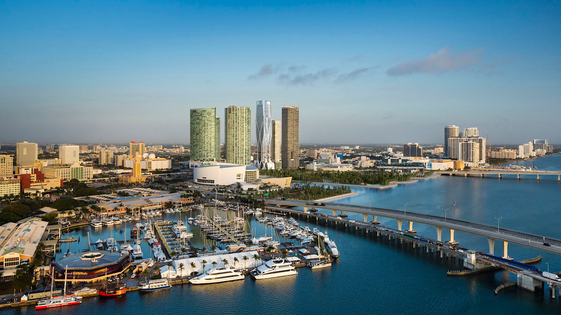 Aerial view of One Thousand Museum in Downtown Miami near a marina and bridge within the waterfront skyline, highlighting luxury and ultra luxury condos.