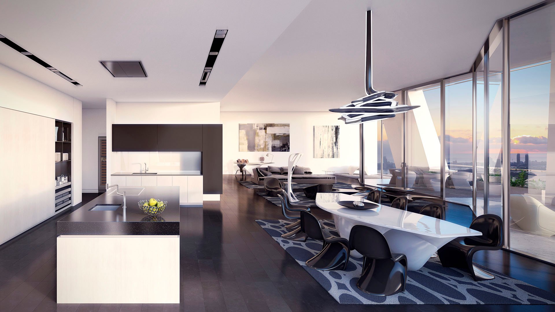 Open chef kitchen and dining area at One Thousand Museum in Downtown Miami flowing into a great room with waterfront glass walls for luxury and ultra luxury condos.