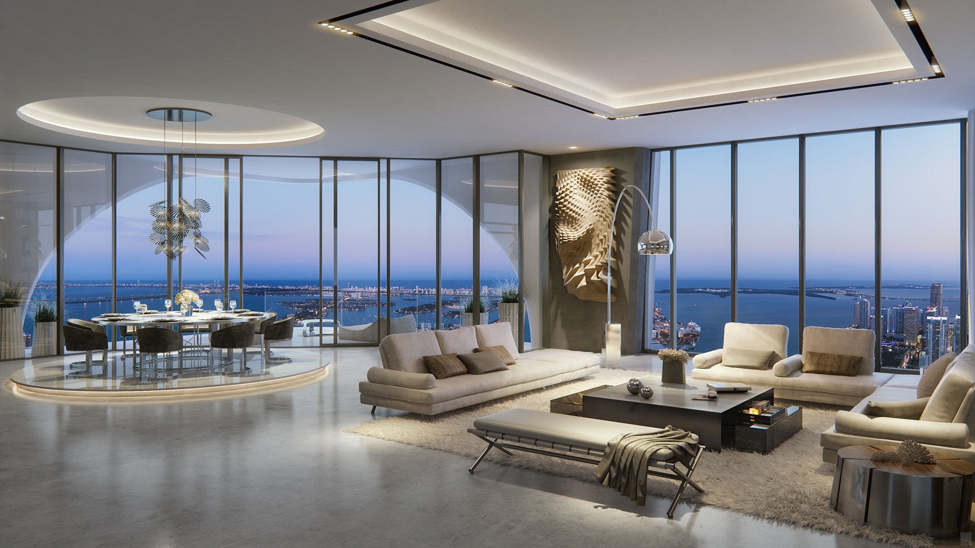 Corner great room at One Thousand Museum in Downtown Miami with a round dining area, floor-to-ceiling glass, and sweeping waterfront views for luxury and ultra luxury condos.