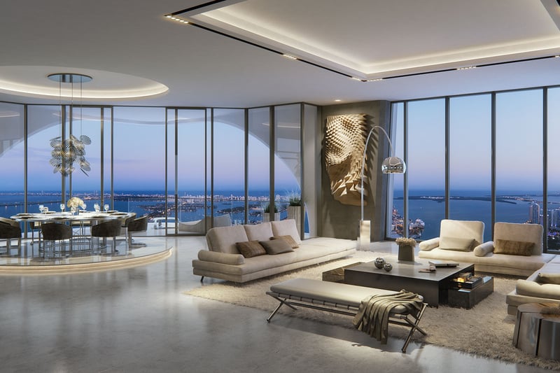 Corner great room at One Thousand Museum in Downtown Miami with a round dining area, floor-to-ceiling glass, and sweeping waterfront views for luxury and ultra luxury condos.