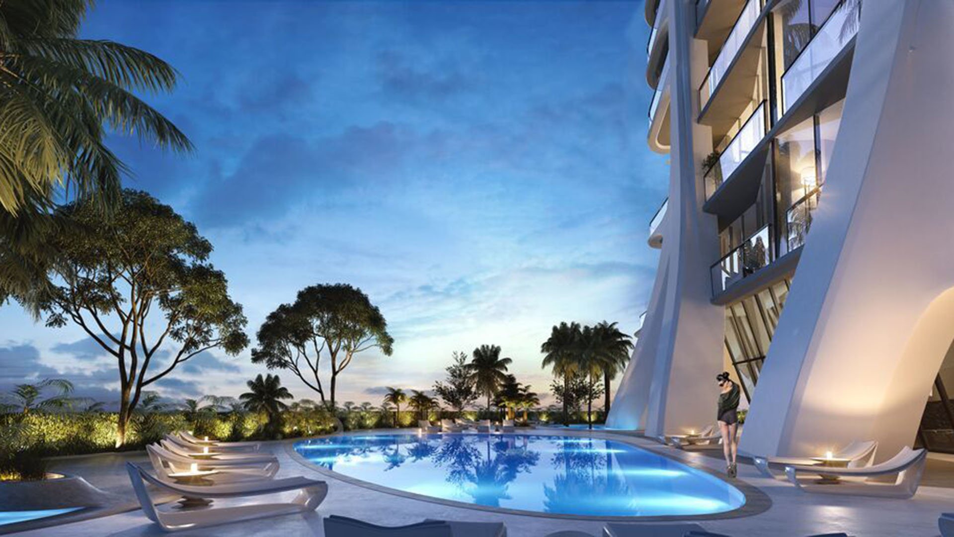 Twilight pool deck at One Thousand Museum in Downtown Miami with curved loungers, palms, and glowing water beside the tower for luxury and ultra luxury condos.