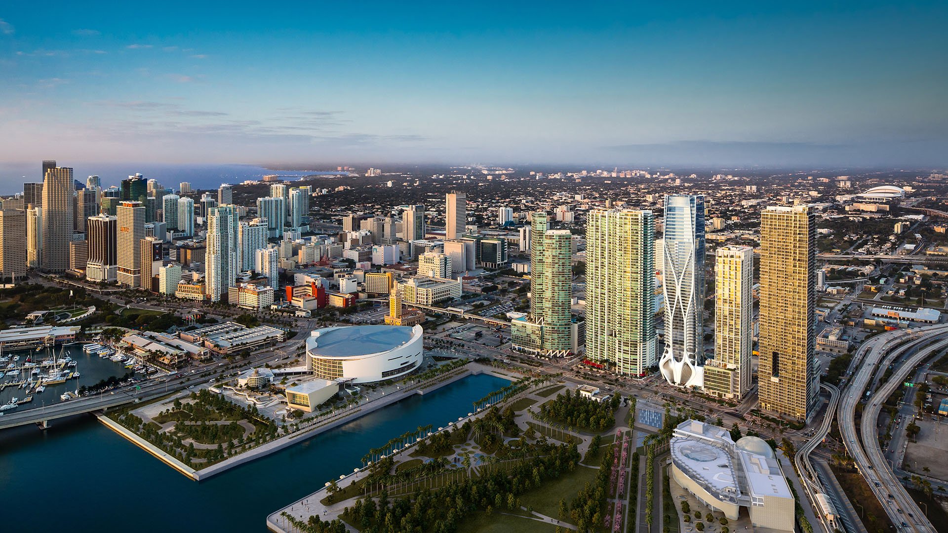 Daytime aerial of One Thousand Museum in Downtown Miami rising over the waterfront skyline and surrounding towers, showcasing luxury and ultra luxury condos.
