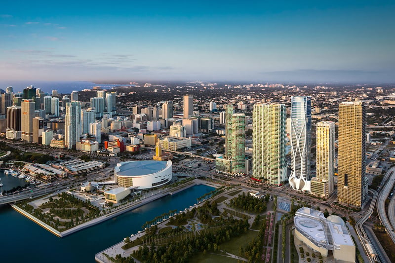 Daytime aerial of One Thousand Museum in Downtown Miami rising over the waterfront skyline and surrounding towers, showcasing luxury and ultra luxury condos.