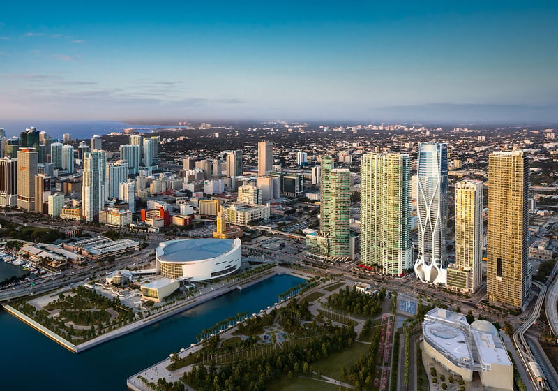 Daytime aerial of One Thousand Museum in Downtown Miami rising over the waterfront skyline and surrounding towers, showcasing luxury and ultra luxury condos.