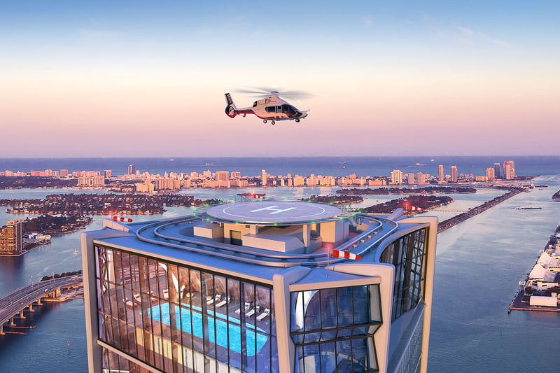 Rooftop helipad and pool at One Thousand Museum in Downtown Miami with a helicopter above the waterfront at sunset, serving luxury and ultra luxury condos.