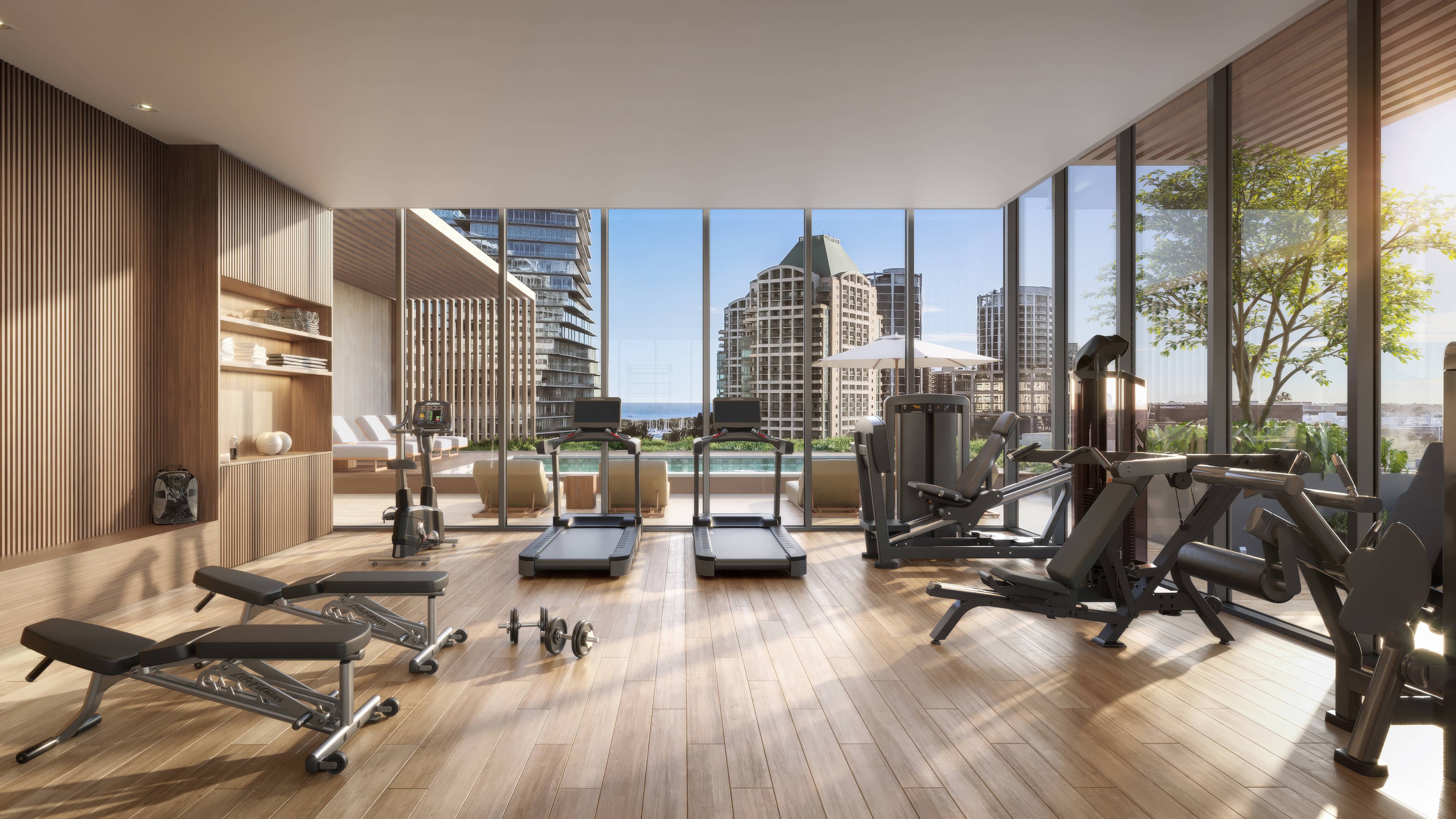 Opus Coconut Grove gym interior with city view, showcasing luxury and ultra luxury preconstruction condos amenities in Miami. Featuring modern.