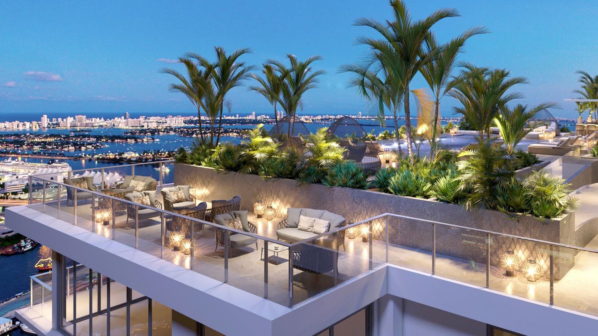 Origin Residences Bay Harbor Islands rooftop terrace at dusk with palm trees, outdoor lounge seating and Biscayne Bay skyline views, showcasing luxury and ultra luxury preconstruction condos in Bay Harbor Islands, Miami, Florida.