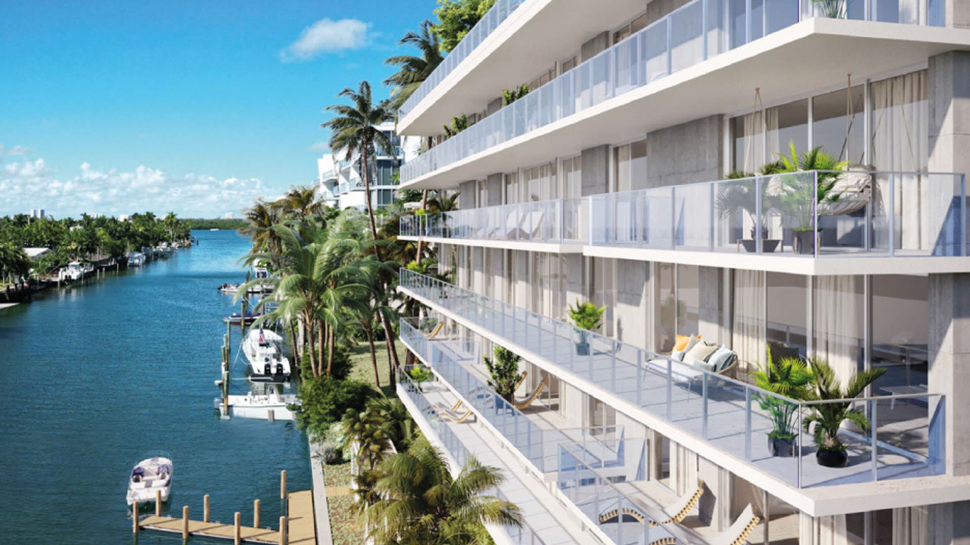 Origin Residences Bay Harbor Islands waterfront canal exterior side view with glass balconies, palm trees and private boat docks in Miami, Florida, showcasing luxury and ultra luxury preconstruction condos on the water.