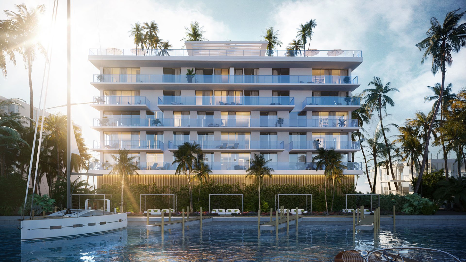 Sunrise marina view of Origin Residences Bay Harbor Islands waterfront building with glass balconies, palm trees and docks, Miami, Florida, featuring luxury and ultra luxury preconstruction condos with boat slips.