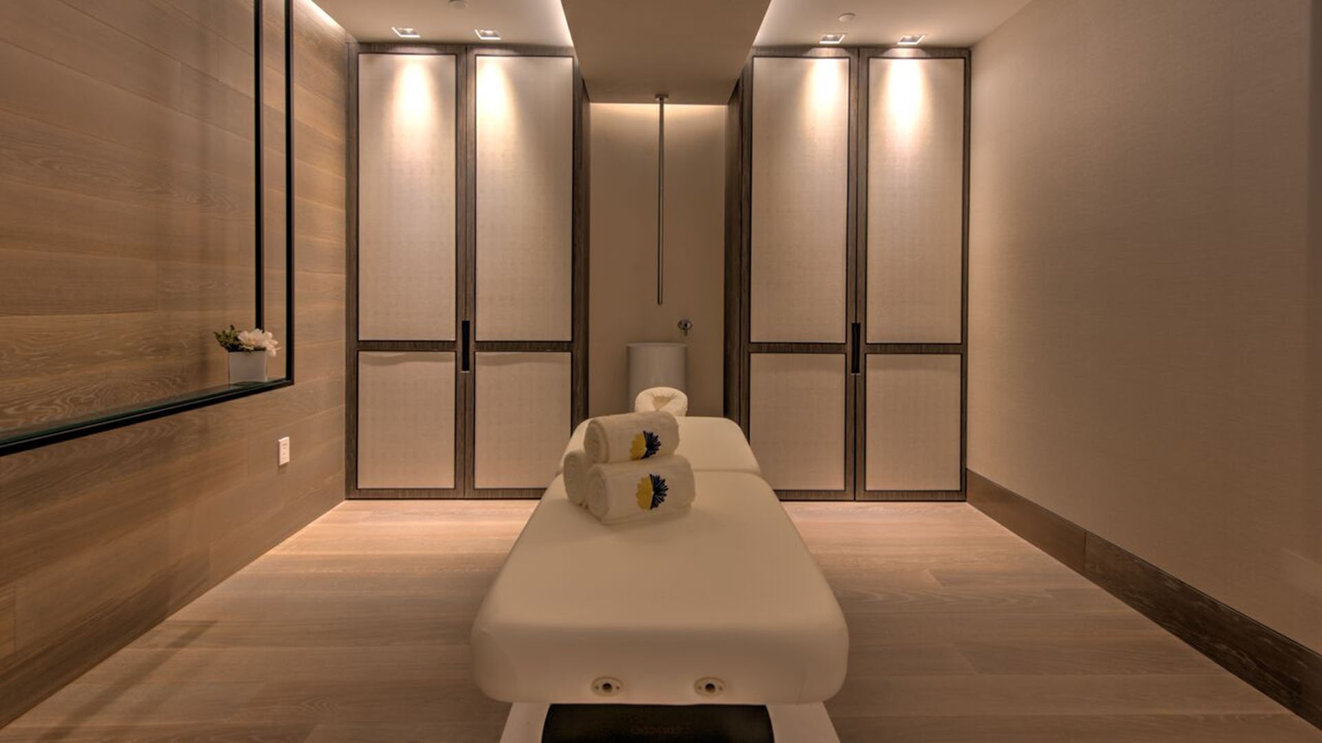 Private massage suite at Palazzo del Sol, Fisher Island, highlighting luxury and ultra luxury condos with warm wood paneling, soft lighting, and a tranquil treatment room.